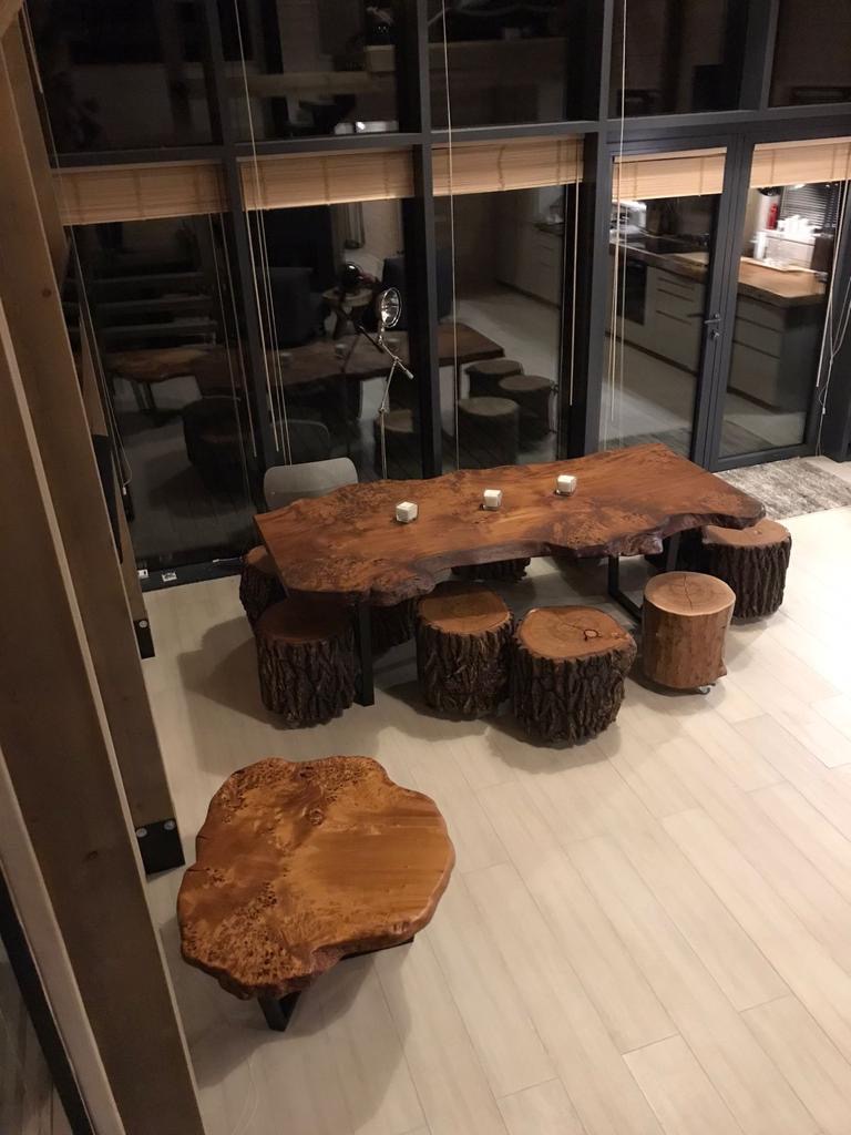Hand-scribed live-edge timber dining table with bespoke carved stools in a New Zealand estate interior
